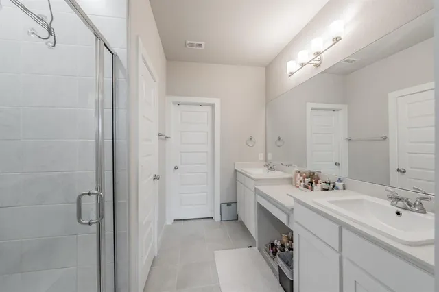 a spacious bathroom with a double vanity sink mirror and bathtub