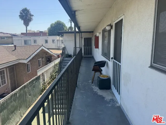 a view of a balcony with chairs and wooden fence