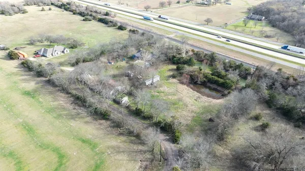 a view of a yard with plants and wooden fence