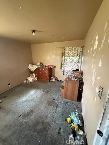 a view of a room with a ceiling fan and window