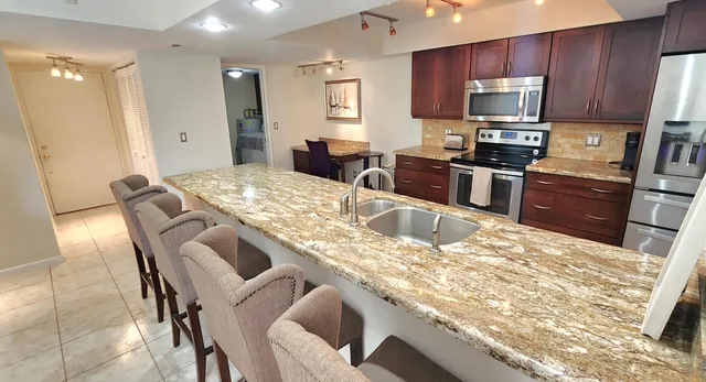 a kitchen with stainless steel appliances granite countertop a sink stove and refrigerator