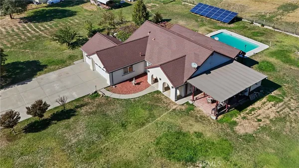 an aerial view of a house with garden space and street view
