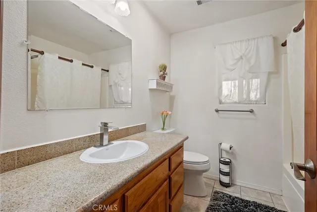 a bathroom with a granite countertop sink toilet and a mirror