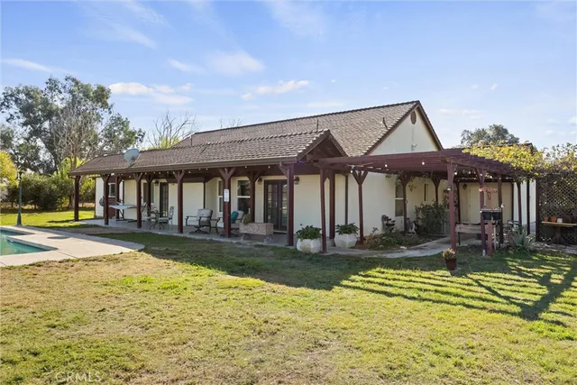 a front view of a house with swimming pool having outdoor seating