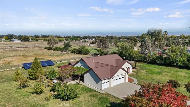 an aerial view of a house with a garden and lake view