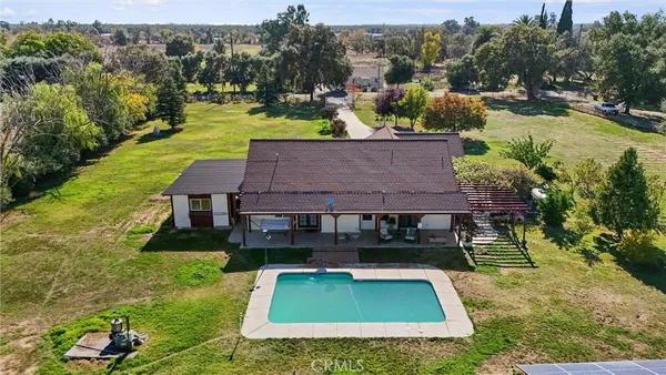 an aerial view of a house with swimming pool garden and patio