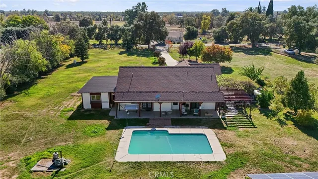 an aerial view of a house with swimming pool garden and patio