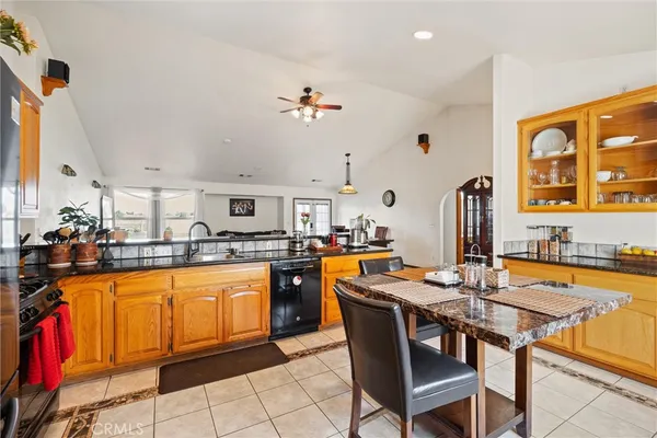 a dining hall with stainless steel appliances granite countertop a dining table and chairs