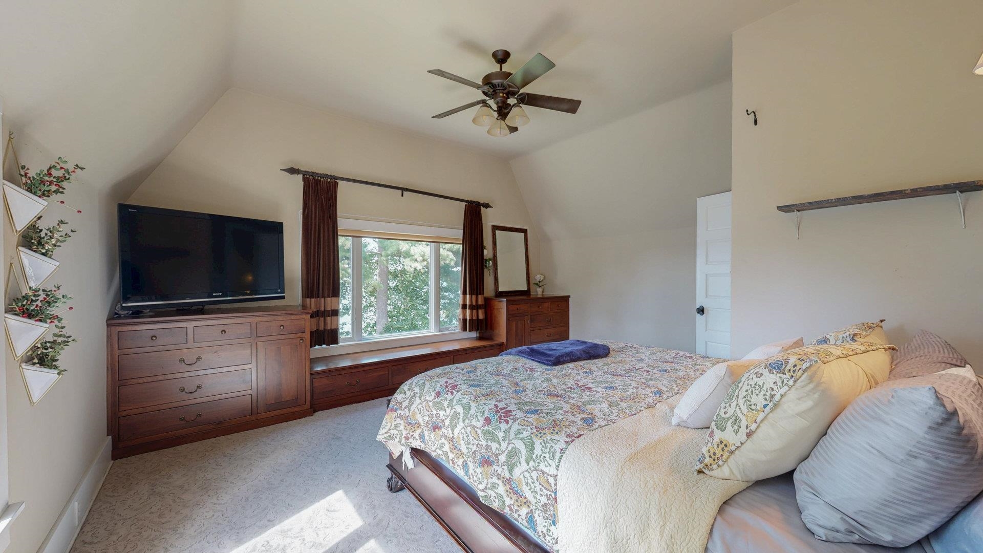N1211 East Side Road Birchwood, WI 54817 - Photo 22 of 70 Bedroom featuring vaulted ceiling, light colored carpet, and a ceiling fan