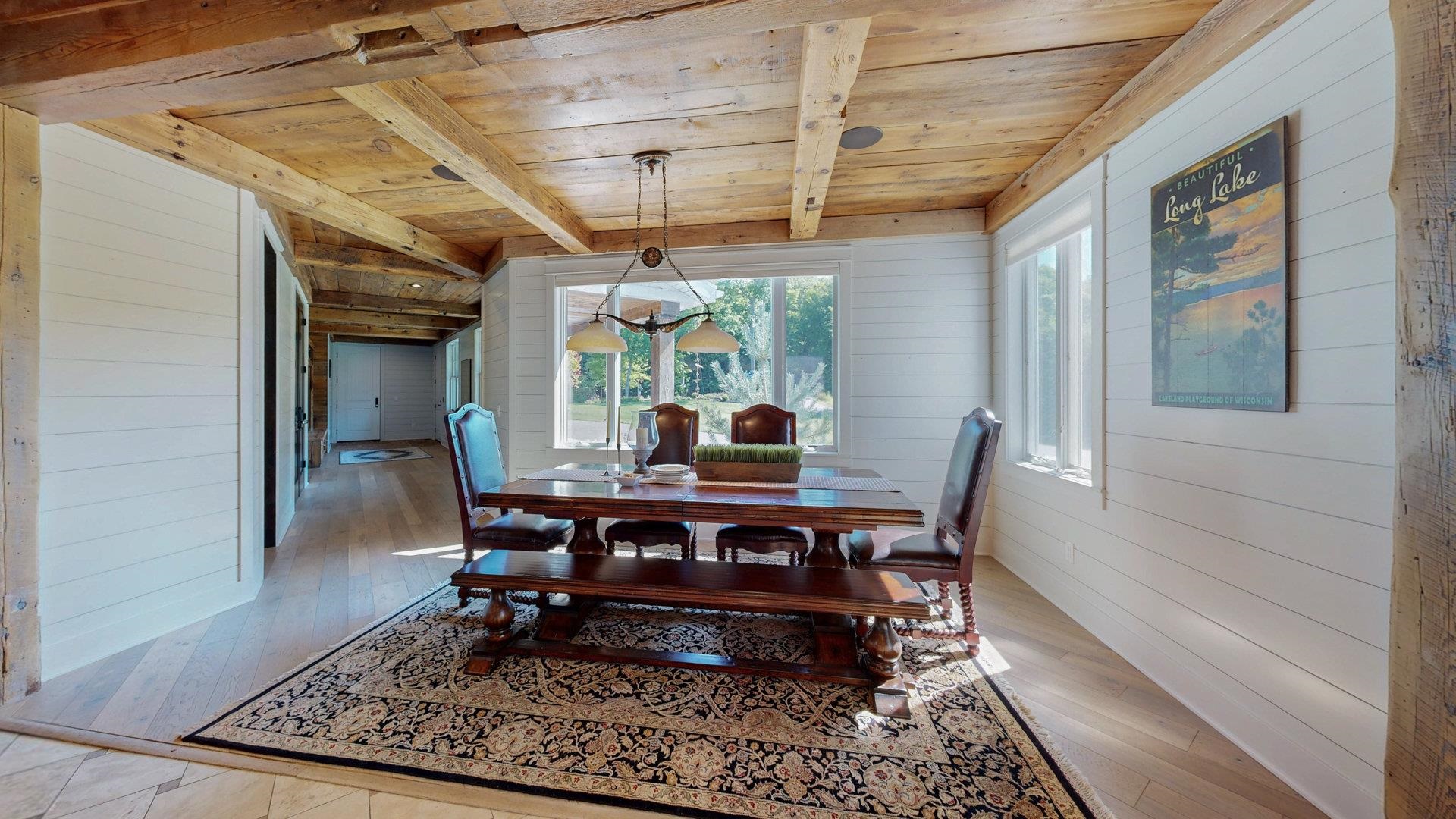 N1211 East Side Road Birchwood, WI 54817 - Photo 25 of 70 Dining space with wood walls, a wooden ceiling with exposed beams, and light wood-style floors