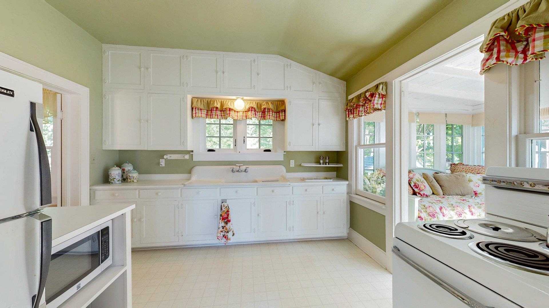 N1211 East Side Road Birchwood, WI 54817 - Photo 58 of 70 Kitchen featuring light flooring, white appliances, lofted ceiling, white cabinetry, and light countertops