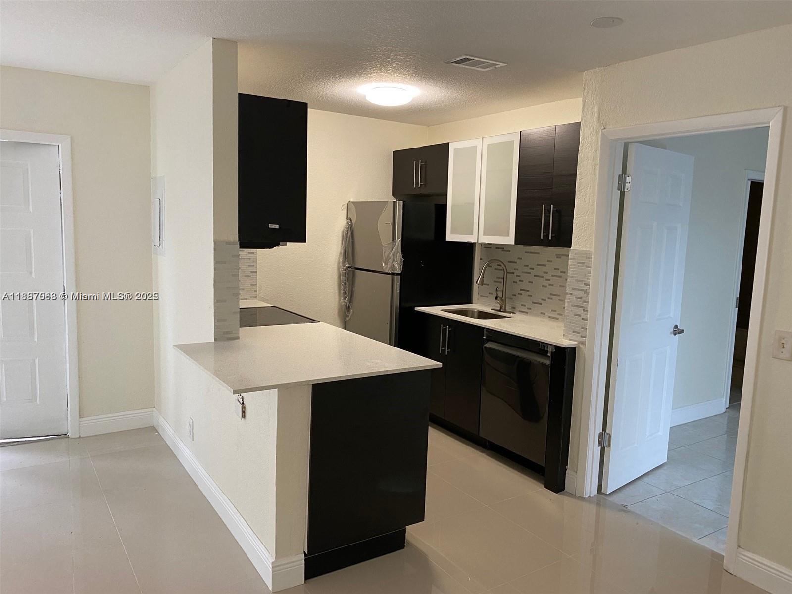 a kitchen with stainless steel appliances kitchen island a refrigerator sink and stove