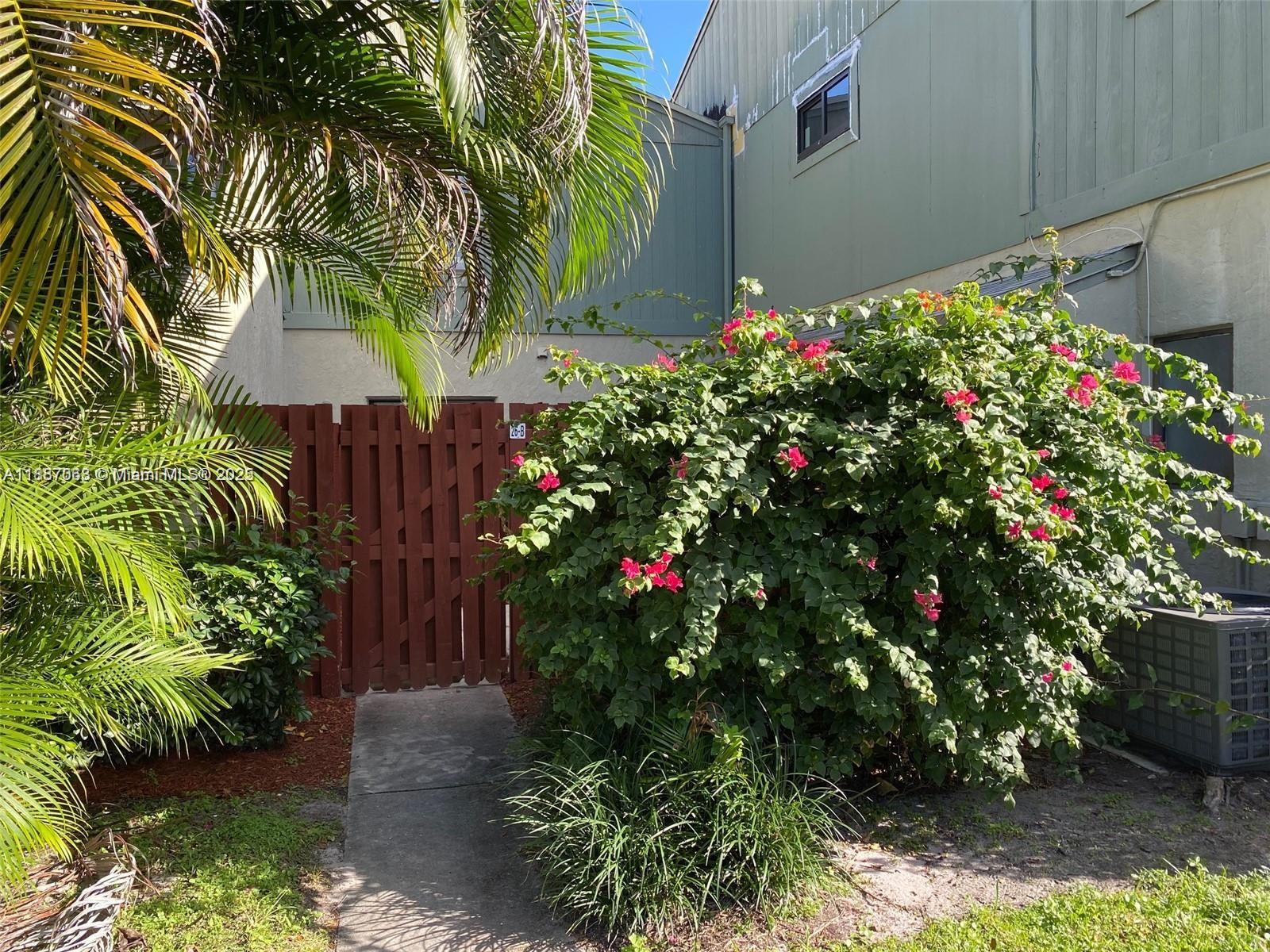 26 Crossings Circle, Unit B Boynton Beach, FL 33435 - Photo 15 of 15 a flower plants and flowers sitting in front of yellow house