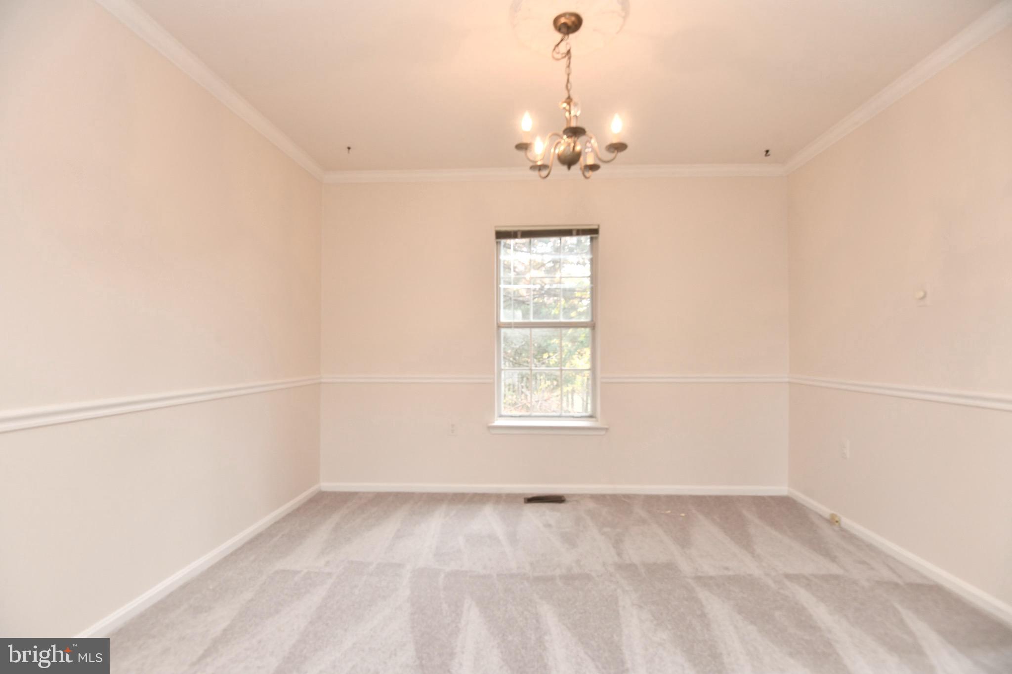 1052 Jeff Ryan Drive Herndon, VA 20170 - Photo 5 of 13 an empty room with a chandelier fan and windows