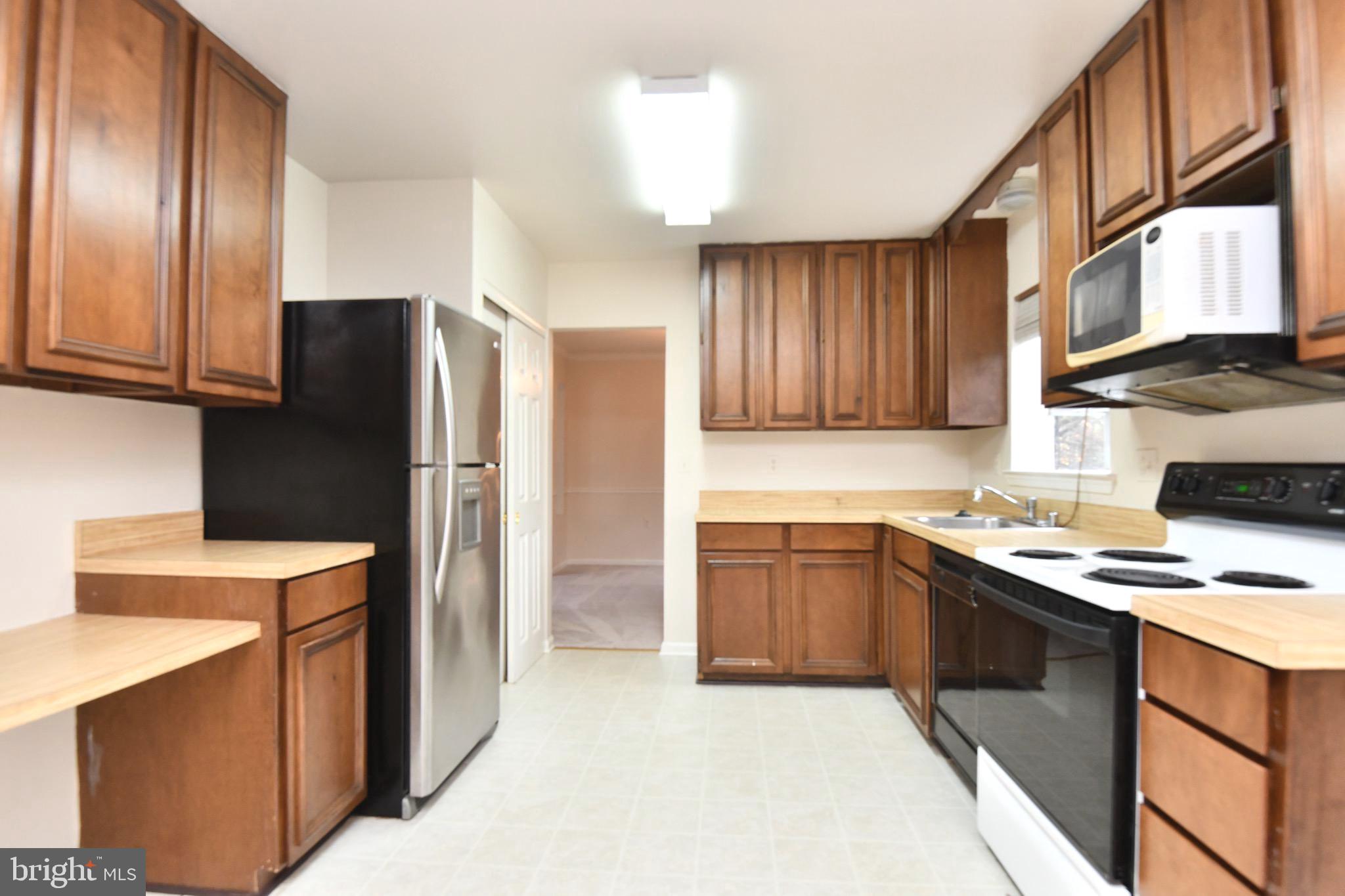 1052 Jeff Ryan Drive Herndon, VA 20170 - Photo 6 of 13 a kitchen with stainless steel appliances granite countertop a refrigerator stove top oven and sink