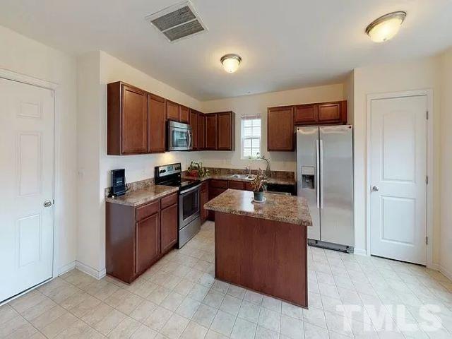 2800 Smooth Stone Trail Raleigh, NC 27610 - Photo 3 of 16 a kitchen with stainless steel appliances granite countertop a stove refrigerator and a microwave