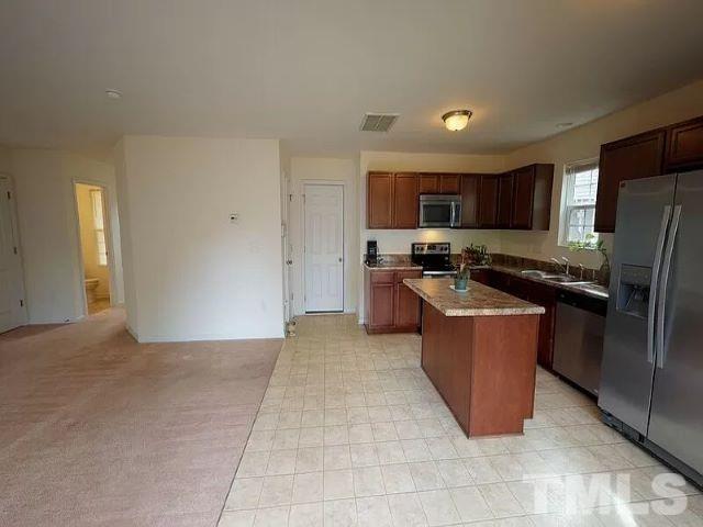 2800 Smooth Stone Trail Raleigh, NC 27610 - Photo 4 of 16 a kitchen with stainless steel appliances granite countertop a stove a refrigerator a sink a microwave and a refrigerator
