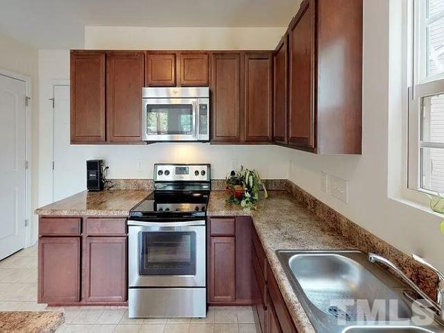 2800 Smooth Stone Trail Raleigh, NC 27610 - Photo 5 of 16 a kitchen with granite countertop a stove sink and cabinets