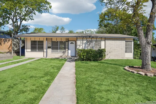 a view of a house with a yard and potted plants