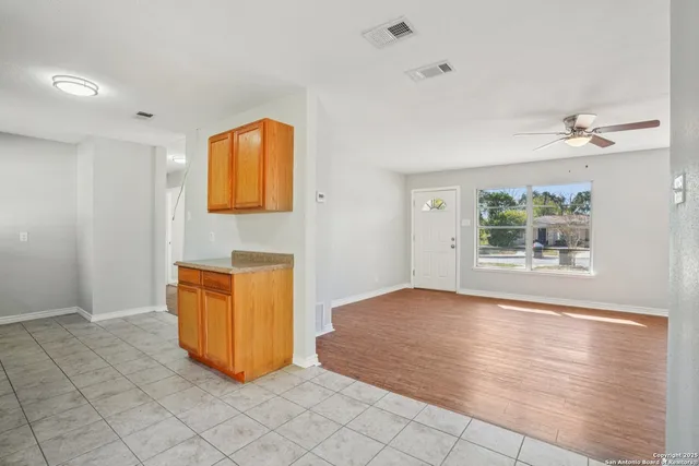 a view of an empty room with window and cabinet