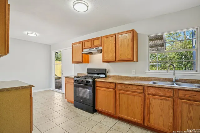 a kitchen with granite countertop a sink stainless steel appliances and cabinets