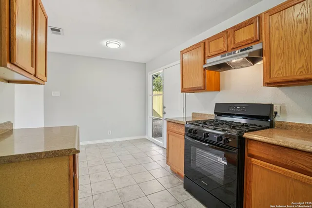a kitchen with granite countertop a stove and a cabinets