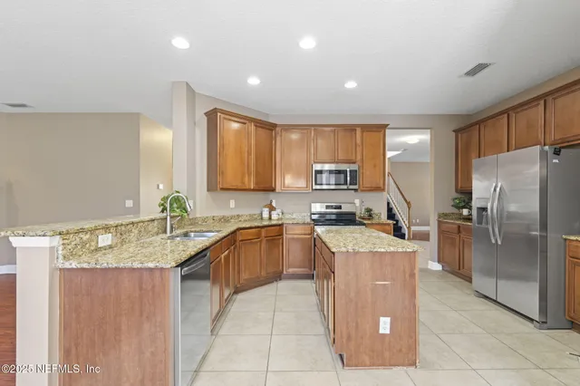 a kitchen with stainless steel appliances granite countertop wooden cabinets and sink
