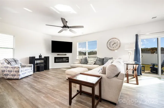 a living room with stainless steel appliances kitchen island furniture and a wooden floor