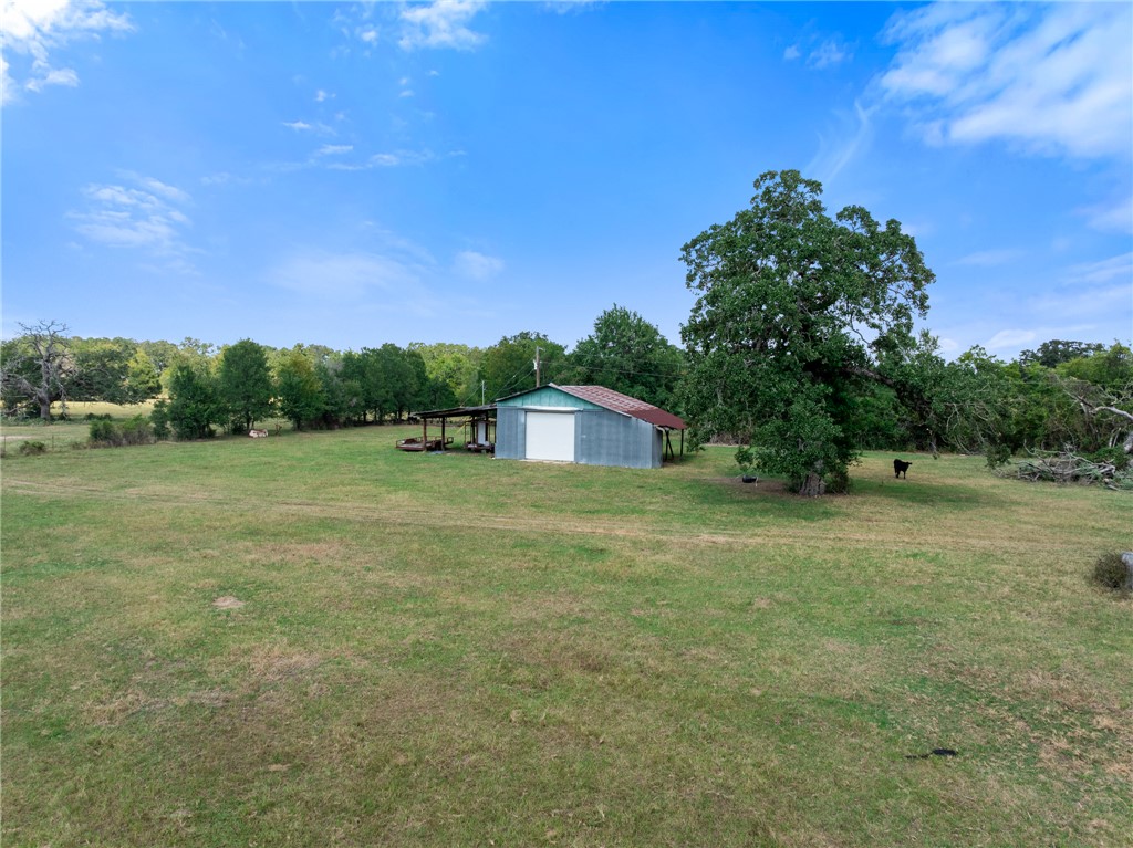 4796 Britten Road Bryan, TX 77807 - Photo 21 of 41 View of grassy yard featuring an outbuilding, a garage, and a view of countryside