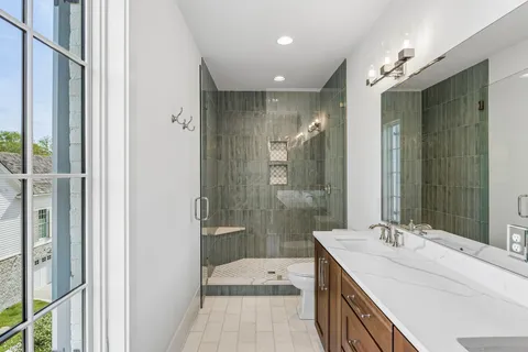 a bathroom with a double vanity sink and mirror with shower