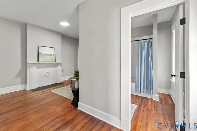 a view of a hallway with wooden floor and closet
