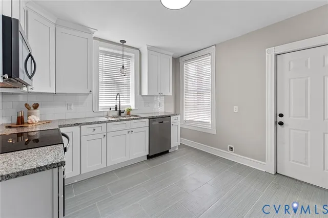a kitchen with granite countertop white cabinets and white appliances