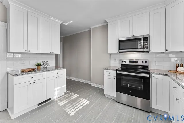 a kitchen with stainless steel appliances granite countertop a stove a sink and a microwave
