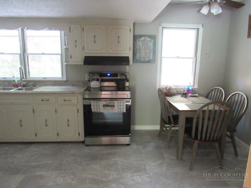 805 Ed Little Road Warrensville, NC 28693 - Photo 45 of 49 a kitchen with a stove a sink and a window