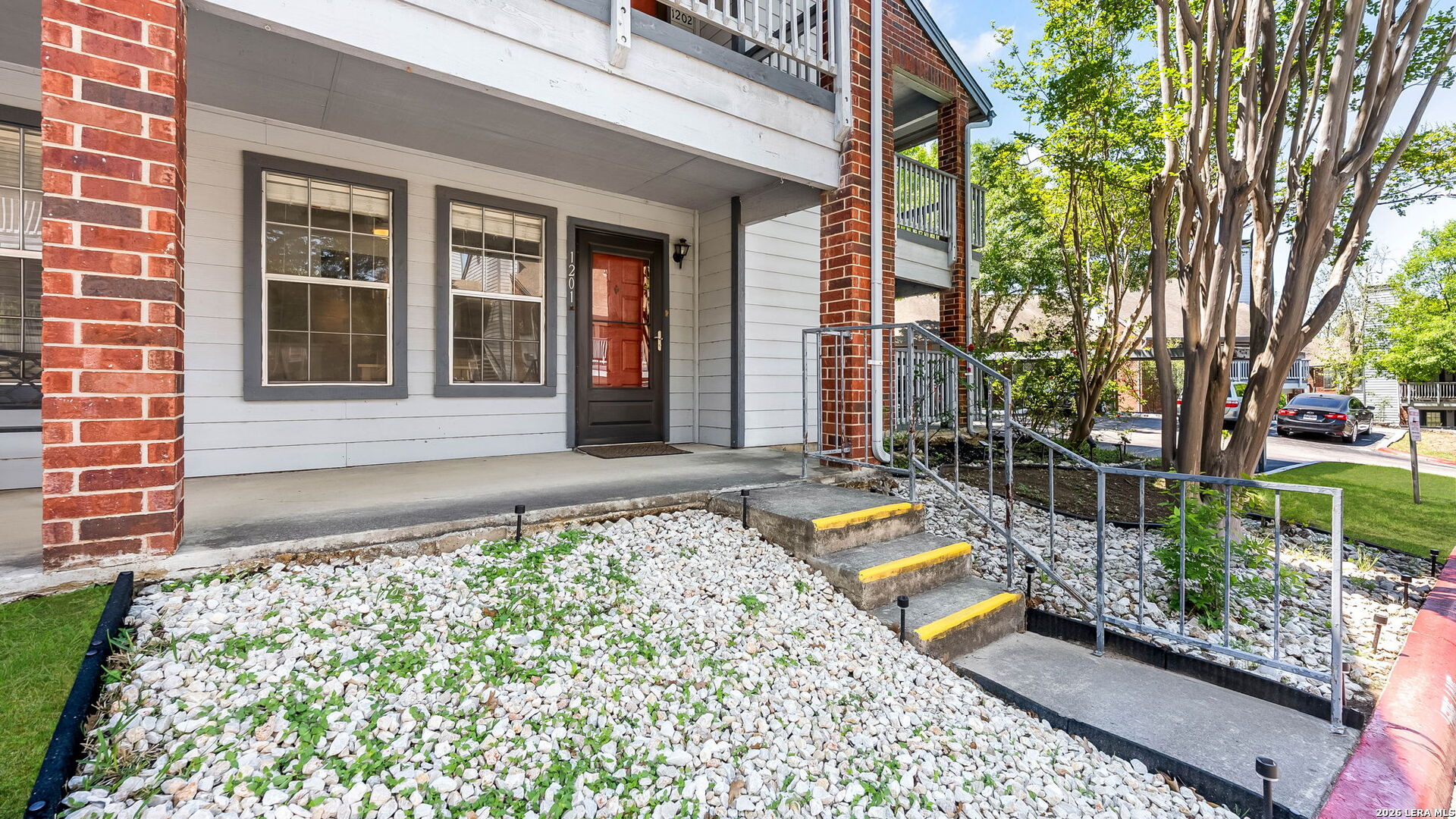 front view of a house with a large window and potted plants
