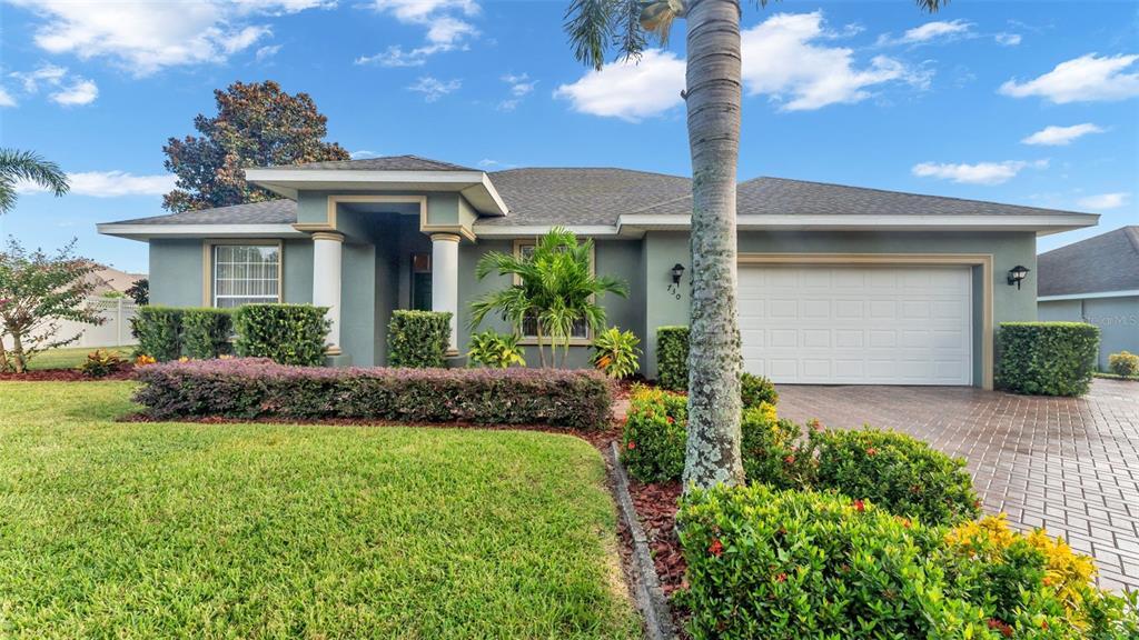 a front view of a house with a garden and plants