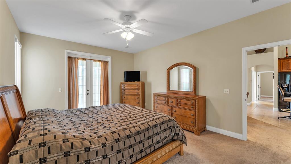 730 Country Walk Cove Eagle Lake, FL 33839 - Photo 16 of 38 a bedroom with a bed and a dresser with mirror