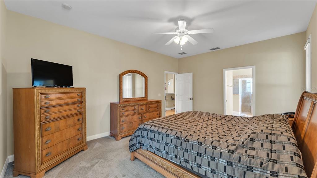 730 Country Walk Cove Eagle Lake, FL 33839 - Photo 17 of 38 a bedroom with a bed and a flat screen tv