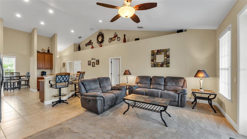 730 Country Walk Cove Eagle Lake, FL 33839 - Photo 3 of 38 a living room with furniture and a chandelier