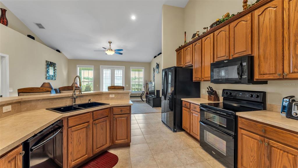 730 Country Walk Cove Eagle Lake, FL 33839 - Photo 8 of 38 a kitchen with stainless steel appliances granite countertop a sink a stove and a refrigerator
