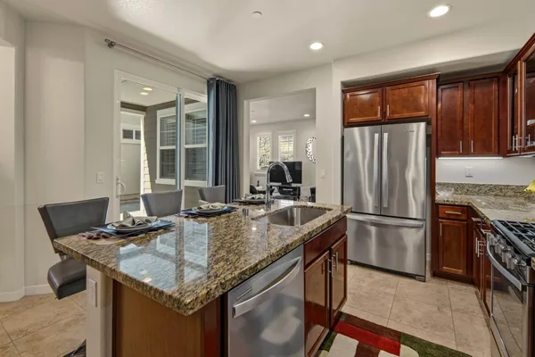a kitchen with kitchen island granite countertop a sink stove and refrigerator
