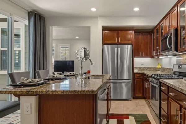 a kitchen with stainless steel appliances granite countertop a sink and a refrigerator