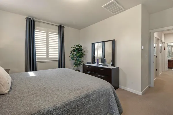 a bedroom with bed and a large mirror