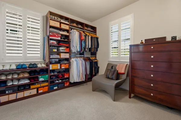 a view of walk in closet with clothes and shoes