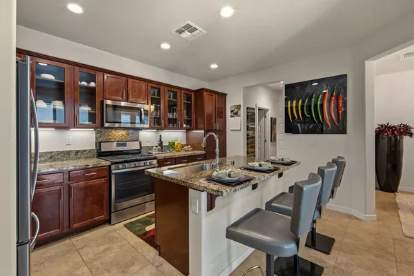 a kitchen with stainless steel appliances granite countertop a stove top oven a sink dishwasher and cabinets