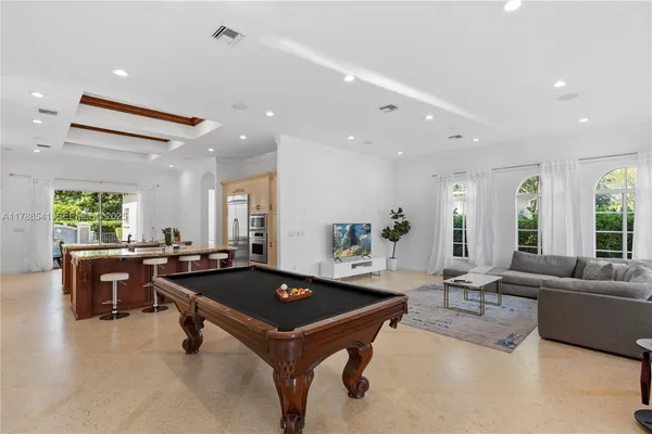 a kitchen with stainless steel appliances kitchen island granite countertop a sink stove and refrigerator