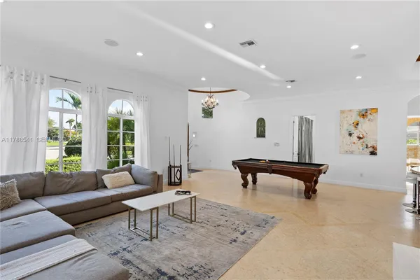 a room with pool table and windows