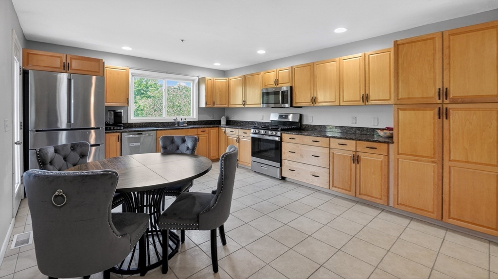 5 Governors Way, Unit B Milford, MA 01757 - Photo 20 of 42 a kitchen with stainless steel appliances granite countertop a stove a sink a microwave a refrigerator and cabinets