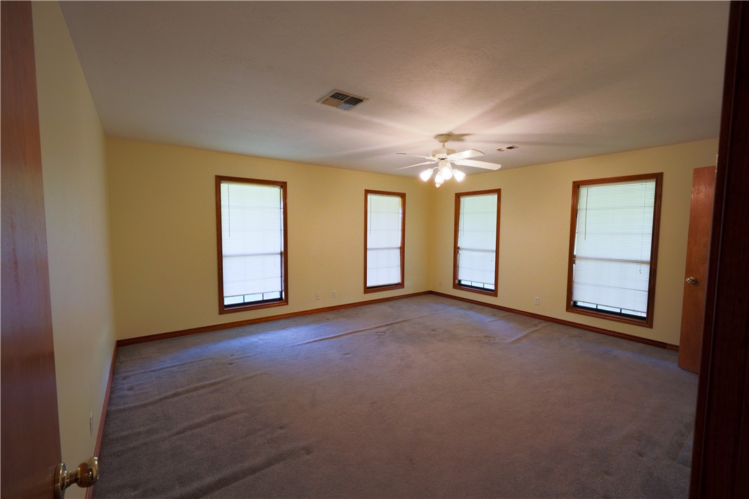 16403-16515 Macey Road Hearne, TX 77859 - Photo 30 of 46 an empty room with chandelier fan and windows