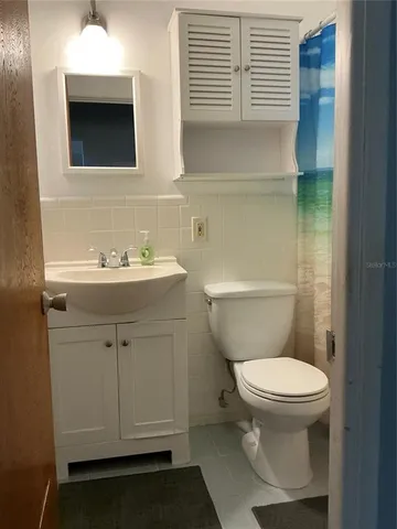 a bathroom with a sink toilet and mirror
